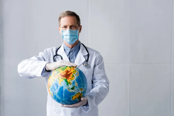 Mature Doctor Latex Gloves Medical Mask Holding Globe Grey — Stock Photo, Image