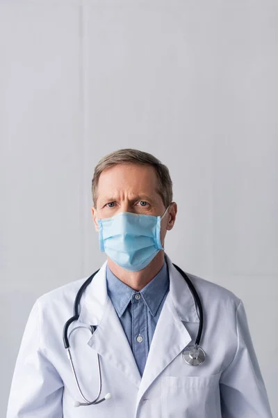 Μεσήλικας Γιατρός Μπλε Ιατρική Μάσκα Και Λευκό Παλτό Γκρι — Φωτογραφία Αρχείου