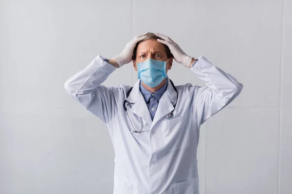 Στρεσαρισμένος Μεσήλικας Γιατρός Μπλε Ιατρική Μάσκα Αγγίζοντας Κεφάλι Γκρι — Φωτογραφία Αρχείου