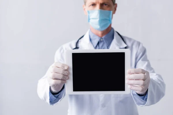 医学面罩中的成熟医生选择焦点 手持白色隔膜空白数码平板 — 图库照片
