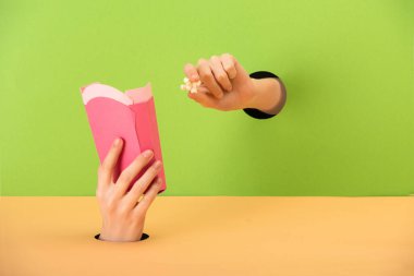 Kırpılmış yeşil ve turuncu üzerine buket ve patlamış mısır tutan kadın manzarası 