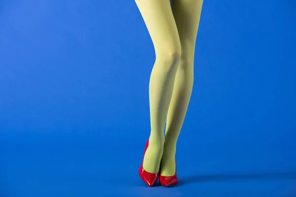 Обрезанный Вид Модели Зеленых Колготках Красных Туфлях Стоящих Синем — стоковое фото
