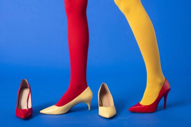Kırmızılı, sarı taytlı, mavi ayakkabılı bir kadın.