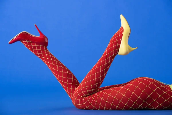Cropped View Model Bright Fishnet Tights Yellow Red Heels Lying — Stock Photo, Image