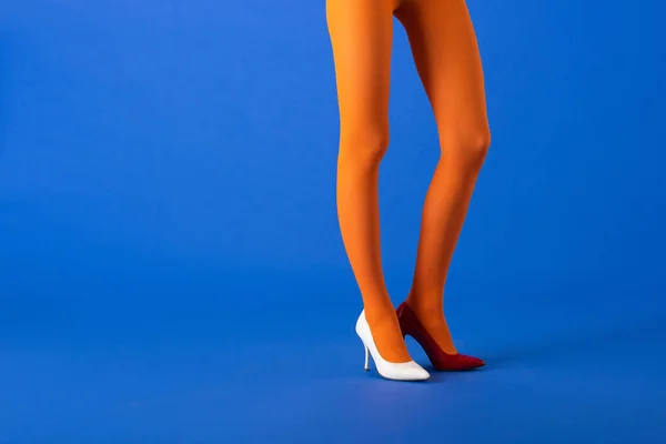 穿着橙色紧身衣的模特的剪影 白色和红色高跟鞋 蓝色站立 — 图库照片