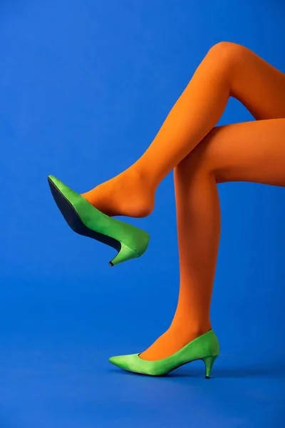Обрезанный Вид Модели Ярко Оранжевых Колготках Зеленых Туфлях Позирующих Синем — стоковое фото