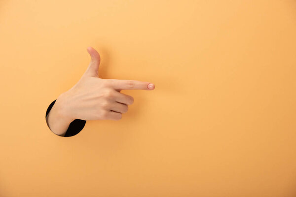 обрезанный вид женщины, указывающей пальцем на оранжевый
 