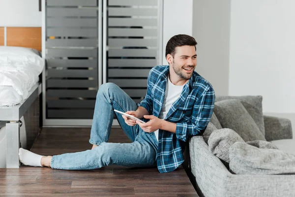 Usmívající Muž Drží Digitální Tablet Zatímco Sedí Podlaze Doma — Stock fotografie