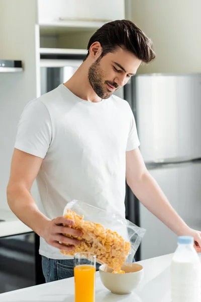 Focus Selettivo Bello Uomo Versando Cereali Ciotola Vicino Bicchiere Succo — Foto Stock