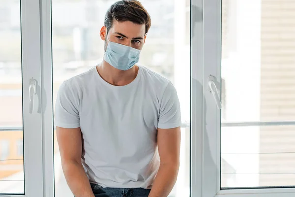 Homem Máscara Médica Olhando Para Câmera Perto Janela Casa — Fotografia de Stock