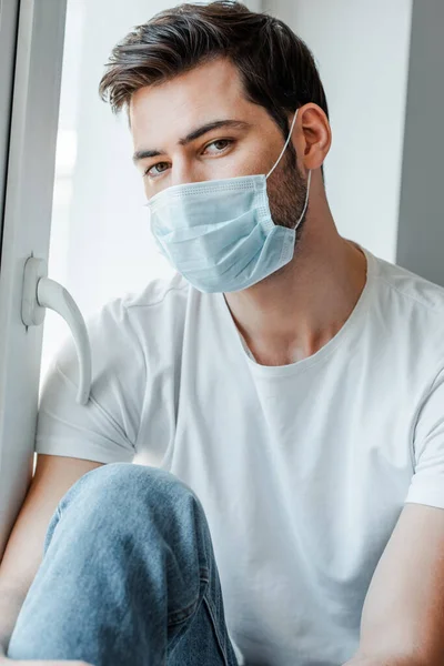 Hombre Con Máscara Médica Mirando Cámara Cerca Ventana — Foto de Stock