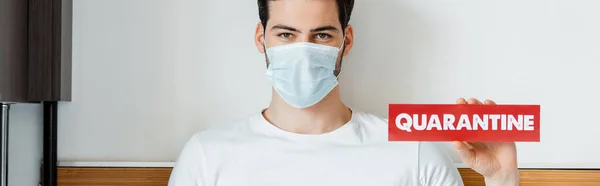 Man Medicinsk Mask Innehav Kort Med Karantän Bokstäver Hemma Panorama — Stockfoto
