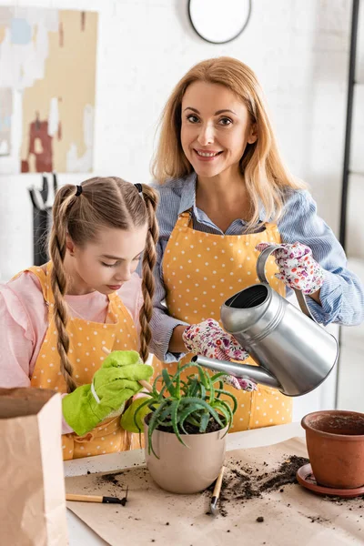 Donna Sorridente Con Figlia Tenendo Annaffiatoio Sopra Vaso Fiori Con — Foto Stock