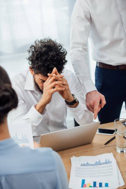 Seçici odak noktası, ofisteki üzgün Afrikalı Amerikalı meslektaşını gösteren bir iş adamı. 
