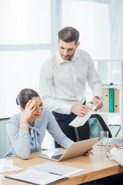 Ofisteki gülümseyen Meksikalı iş kadınının yanındaki belgeye parmağınla işaret eden seçici bir iş kadını. 