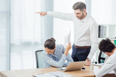 İşadamı, Meksikalı bir iş kadınının elinde belgeyi tuttuğunu işaret ediyor. 
