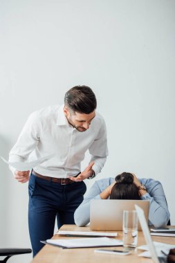 Ofisteki meslektaşının yanında elinde tuttuğu belgenin seçici odak noktası 