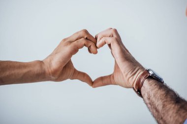 Gri renkte izole edilmiş ellerle aşk işareti gösteren adamlar. 