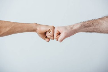 Gri alanda yumruk tokuşturan adamların görüntüsü. 