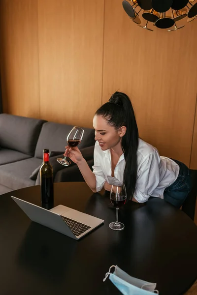 Sorrindo Jovem Segurando Copo Vinho Tinto Durante Chat Vídeo Laptop — Fotografia de Stock