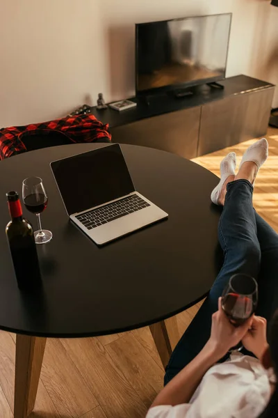 Cropped View Woman Holding Wine Glass While Sitting Legs Table — Stock Photo, Image