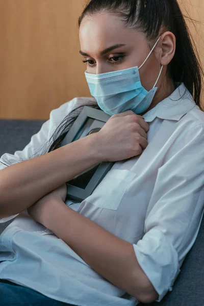 Gestresste Junge Frau Medizinischer Maske Trauert Während Sie Fotorahmen Brustnähe — Stockfoto