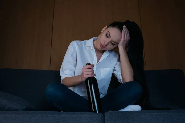 Mujer Deprimida Tocando Cabeza Mientras Está Sentado Sofá Con Botella —  Fotos de Stock