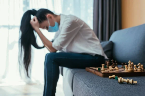 Selective Focus Depressed Woman Medical Mask Sitting Bowed Head Chessboard — Stock Photo, Image