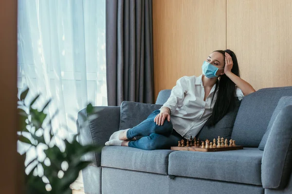 Selective Focus Sad Woman Medical Mask Sitting Chessboard Looking Away — Stock Photo, Image