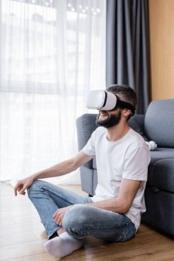 Smiling man using virtual reality headset in living room