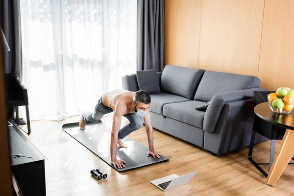 Shirtless Man Medical Mask Training Fitness Mat Laptop Dumbbells Home — Stock Photo, Image
