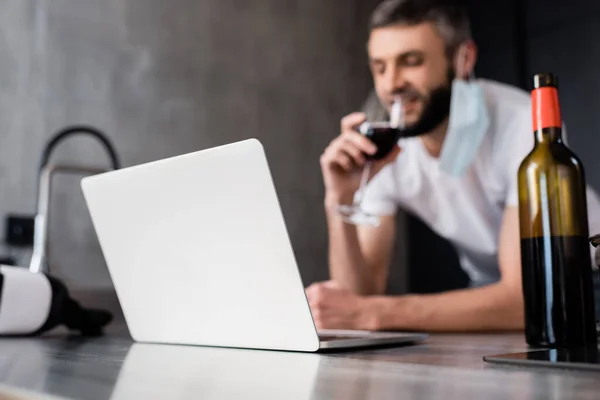 Selektiv Fokus Laptop Köksbänk Och Man Medicinsk Mask Dricka Vin — Stockfoto