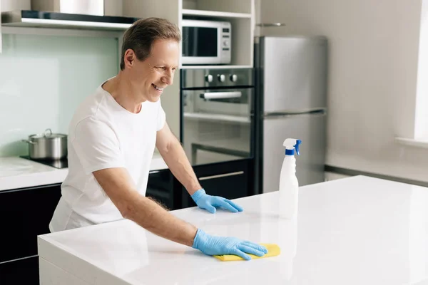 Fröhlicher Mann Gummihandschuhen Der Lappen Hält Während Küchentisch Putzt — Stockfoto