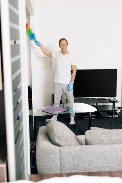 Foco Seletivo Homem Feliz Segurando Escova Espanador Durante Limpeza Sala — Fotografia de Stock