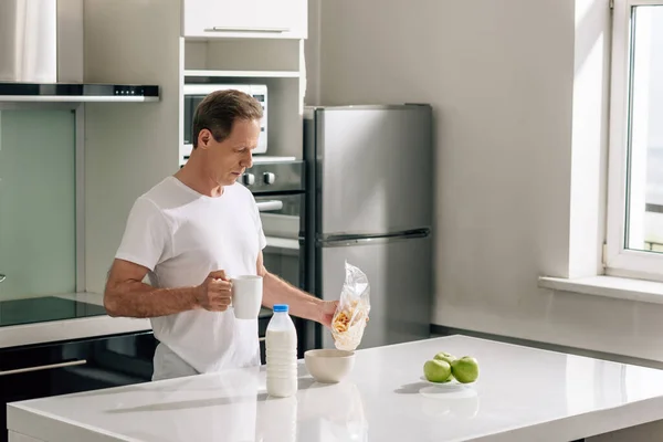 Handsome Man Pouring Cornflakes Bowl Bottle Milk Apples — Stock Photo, Image