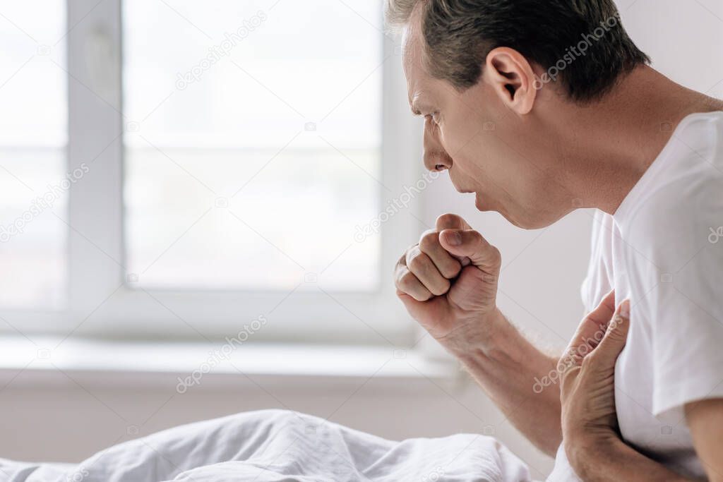 side view of sick man coughing at home 