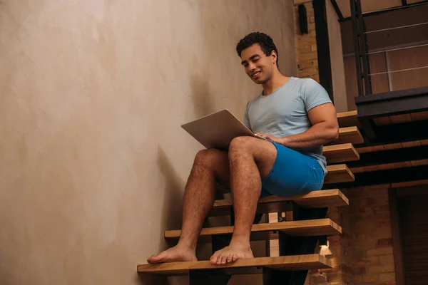 Счастливый Бирасовый Мужчина Использует Ноутбук Лестнице Дома Самоизоляции — стоковое фото