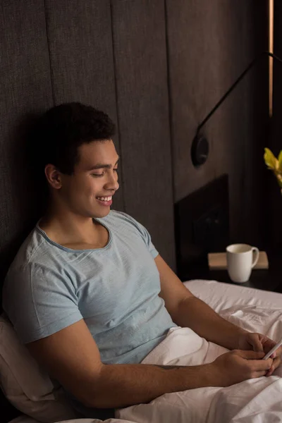 Young Smiling Mixed Race Man Using Smartphone Bed Self Isolation — Stock Photo, Image