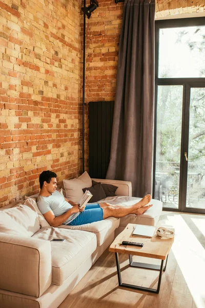 Young Mixed Race Man Reading Book While Chilling Living Room — Stock Photo, Image