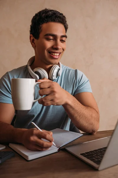 Sorridente Freelance Razza Mista Possesso Tazza Caffè Mentre Lavora Con — Foto Stock