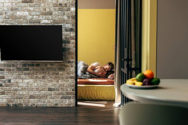 Boş TV ekranının seçici odak noktası yatakta çift yakın 
