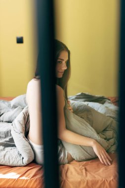 Yatakta oturan çekici ve şehvetli kadının seçici odağı 