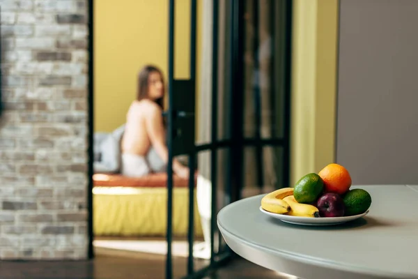 selective focus of tasty fruits near woman in bedroom