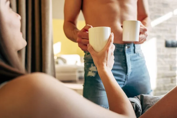 Selective Focus Muscular Man Holding Cups Attractive Woman Bedroom — Stock Photo, Image