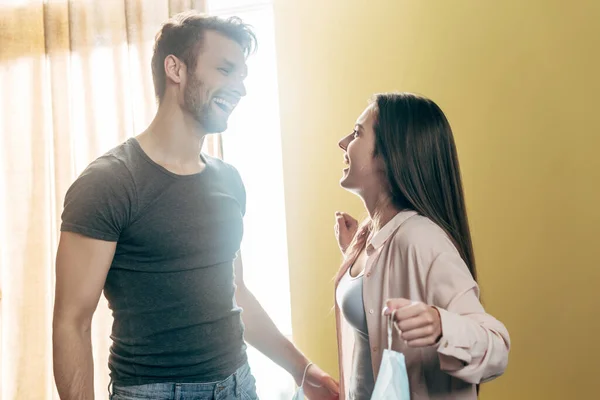 Mulher Feliz Segurando Máscara Médica Olhando Para Namorado Bonito Fim — Fotografia de Stock