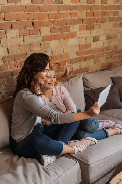 Mosolygó Anya Lánya Miután Video Chat Digitális Tabletta Kanapén — Stock Fotó