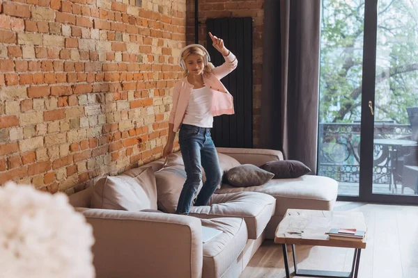 自宅でソファで踊るヘッドフォンで子供の選択的な焦点 — ストック写真