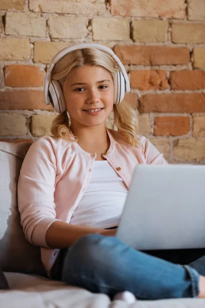 Selective Focus Smiling Kid Headphone Looking Camera Laptop Couch — Stock Photo, Image