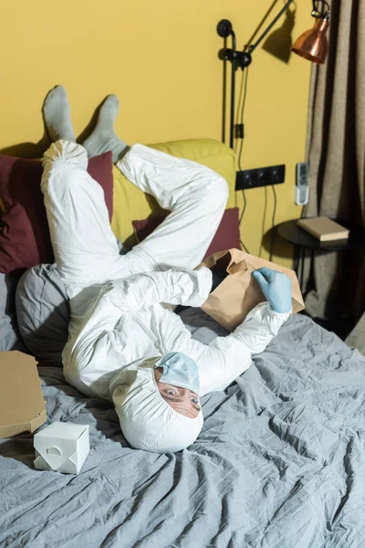 Человек Медицинской Маске Латексных Перчатках Защитном Костюме Лежит Рядом Пакетами — стоковое фото