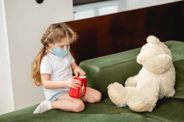 Niedliches Kind Medizinischer Maske Hält Verbandskasten Der Nähe Von Teddybär — Stockfoto